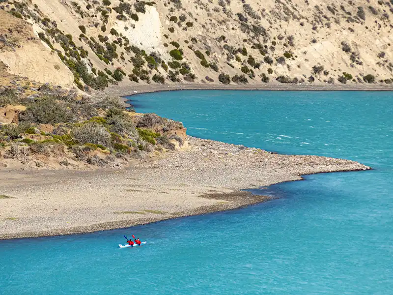 Vista de un kayak navegando el Río Santa Cruz desde un punto panorámico, inmensidad de la estepa en el tour Darwin Experience.