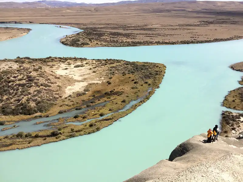 Turistas explorando los acantilados de la estepa patagónica, caminata histórica y reconocimiento geológico en el tour Darwin Experience.