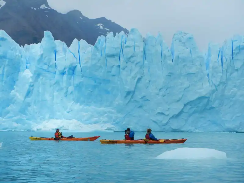 Kayaks navegando entre témpanos de hielo frente a la cara norte del Glaciar Perito Moreno, aventura técnica en el Lago Argentino.