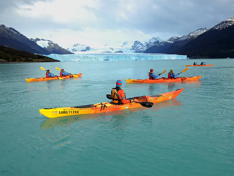 Grupo de kayaks regresando a la costa tras la travesía frente al Glaciar Perito Moreno, fin de la expedición en el Lago Argentino.