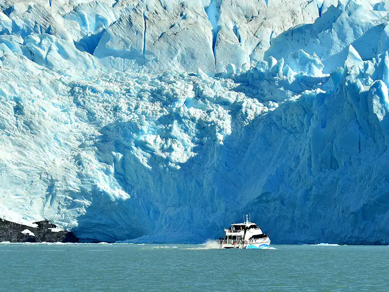 Catamarán frente a la alta pared del Glaciar Spegazzini, escala del frente de hielo en el Parque Nacional Los Glaciares.