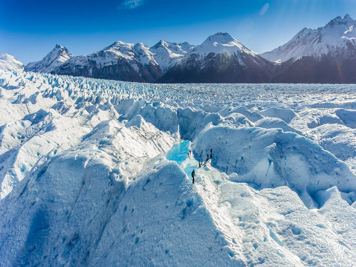 Senderistas con grampones explorando el centro del Glaciar Perito Moreno, trekking de alta intensidad en el tour Big Ice.