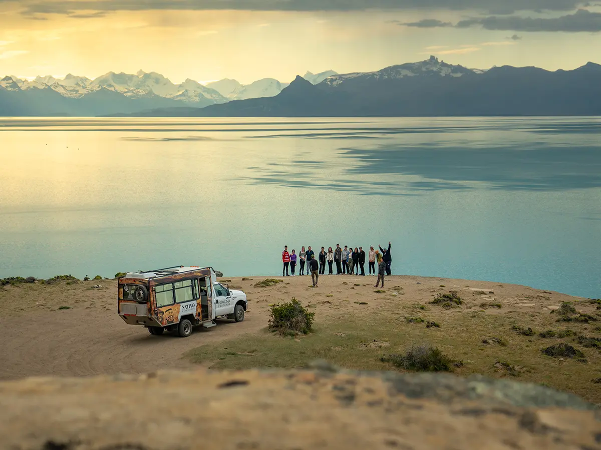 Turistas explorando las cuevas con arte rupestre tehuelche frente al Lago Argentino, excursión cultural en El Calafate.